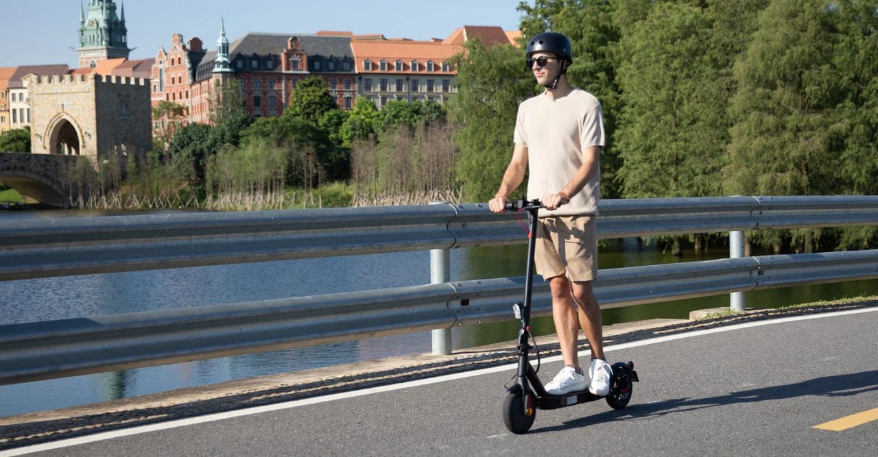 iScooter E9TMAX Mann auf E-Scooter mit Helm